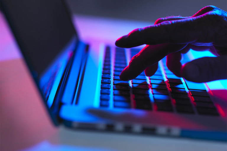 A person types on a computer keyboard.