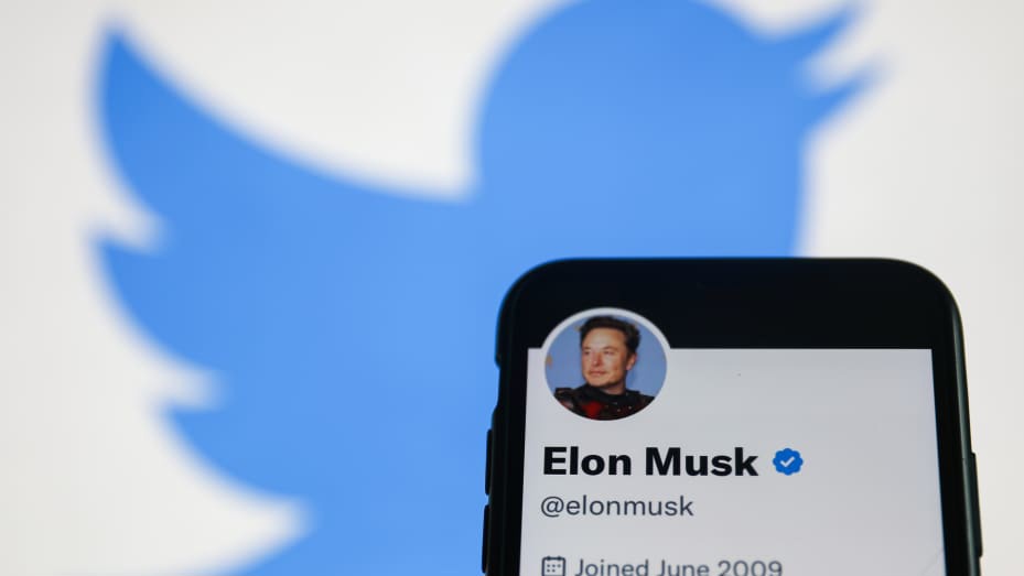 Elon Musk Twitter account displayed on a phone screen and Twitter logo displayed on a screen in the background are seen in this illustration photo taken in Krakow, Poland on November 22, 2022.